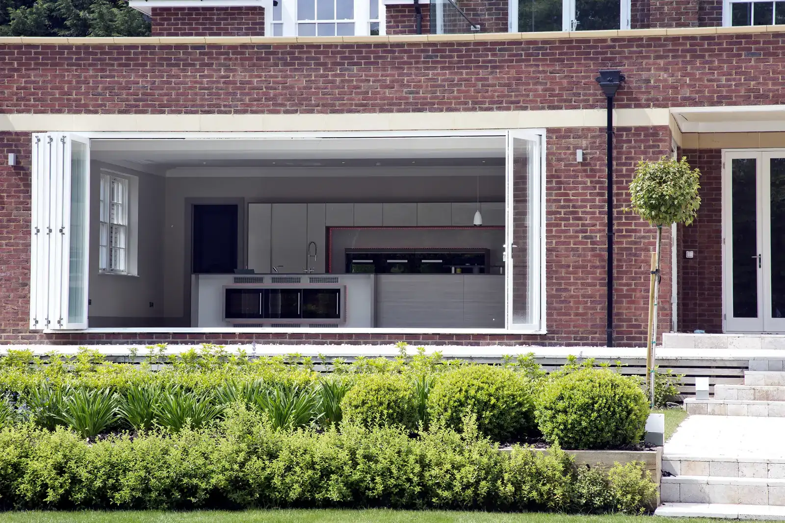 Timber bifold doors opened from a kitchen to the garden