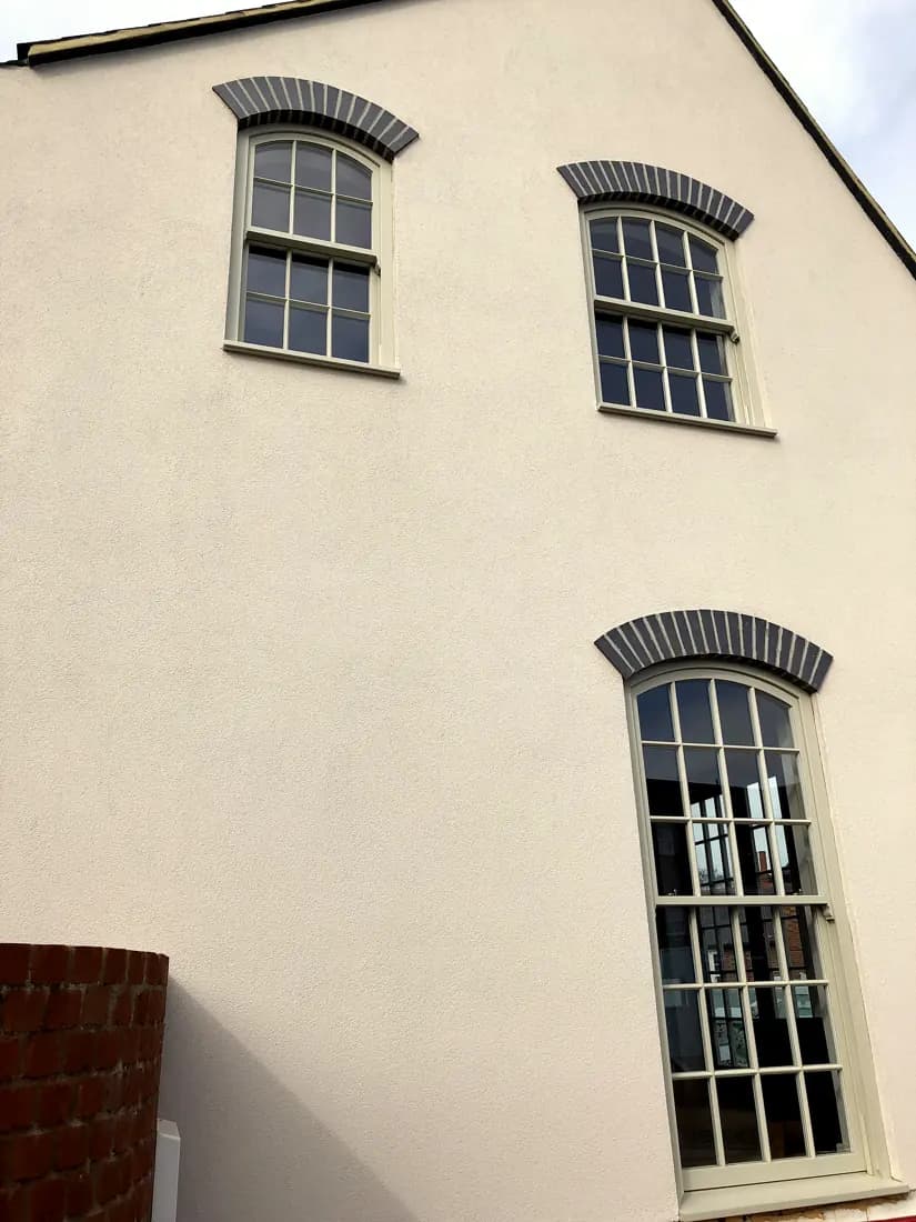 Rendered gable elevation with three arched-head timber sash windows