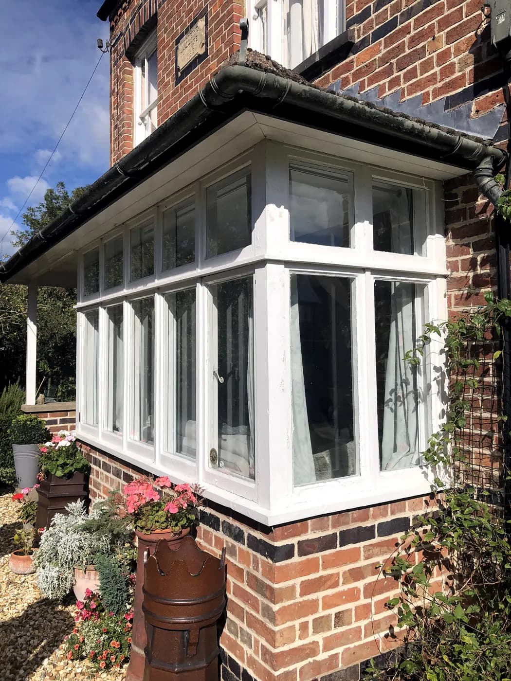 White timber bay casement window with deep brick cill on a period brick house