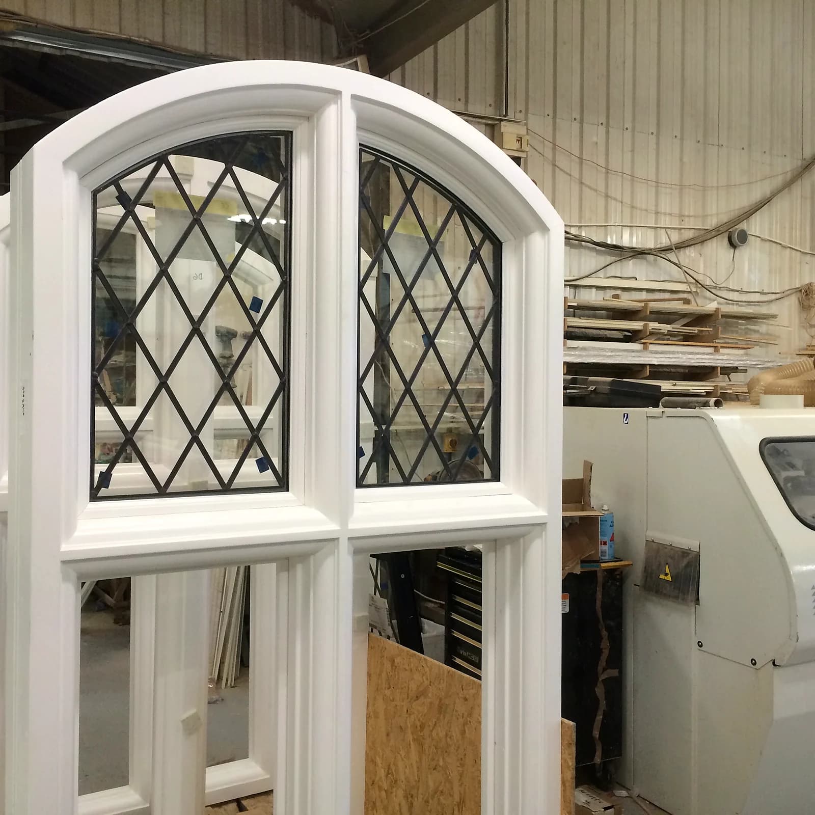 Detail of arched leaded-light casement sashes with diamond leadwork in the workshop