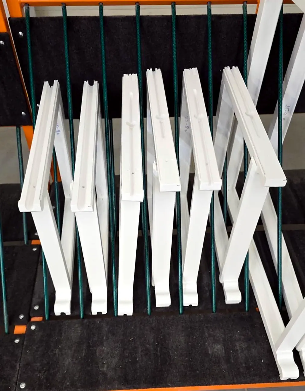 Painted timber window components drying on the workshop rack