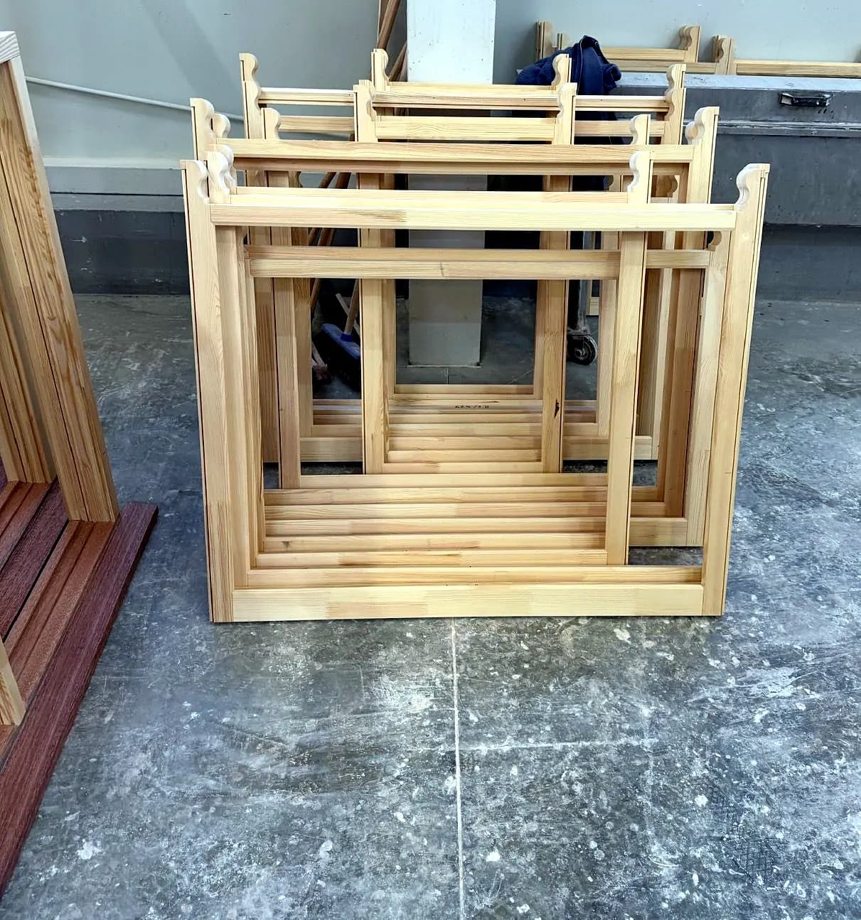 A finished timber sash window resting on trestles in the workshop