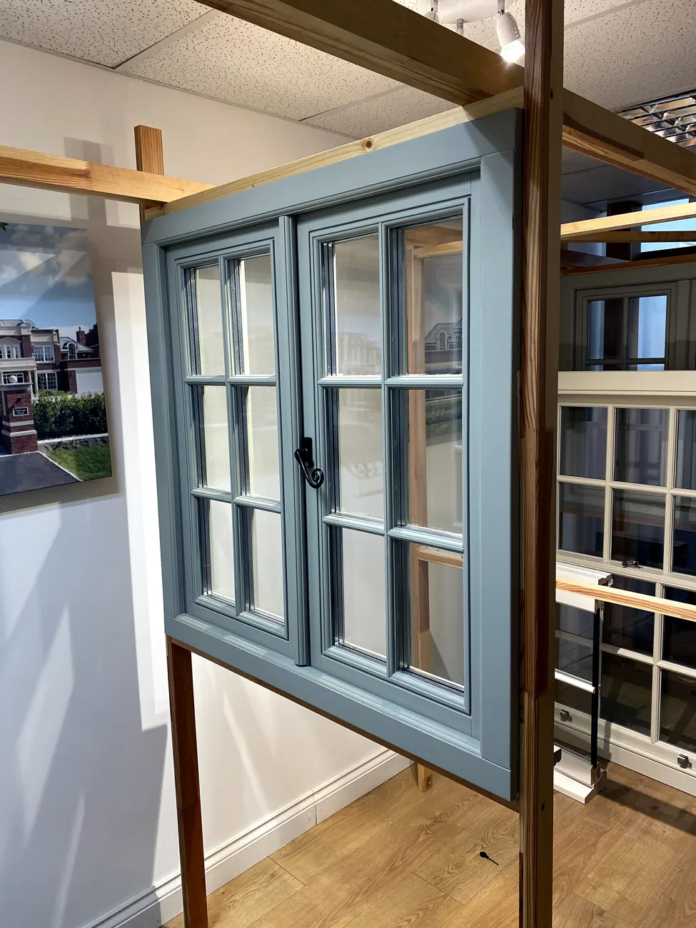 Sage-green timber Georgian casement window pair with multi-pane glazing and period ironmongery