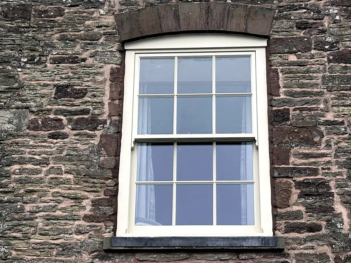 Close detail of a cream Georgian sash window with slim glazing bars