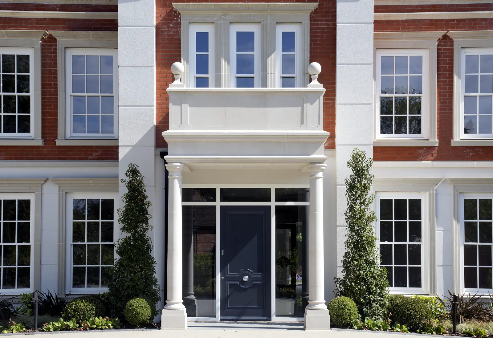 Rear garden elevation of a Surrey new-build home with sash windows and lavender borders